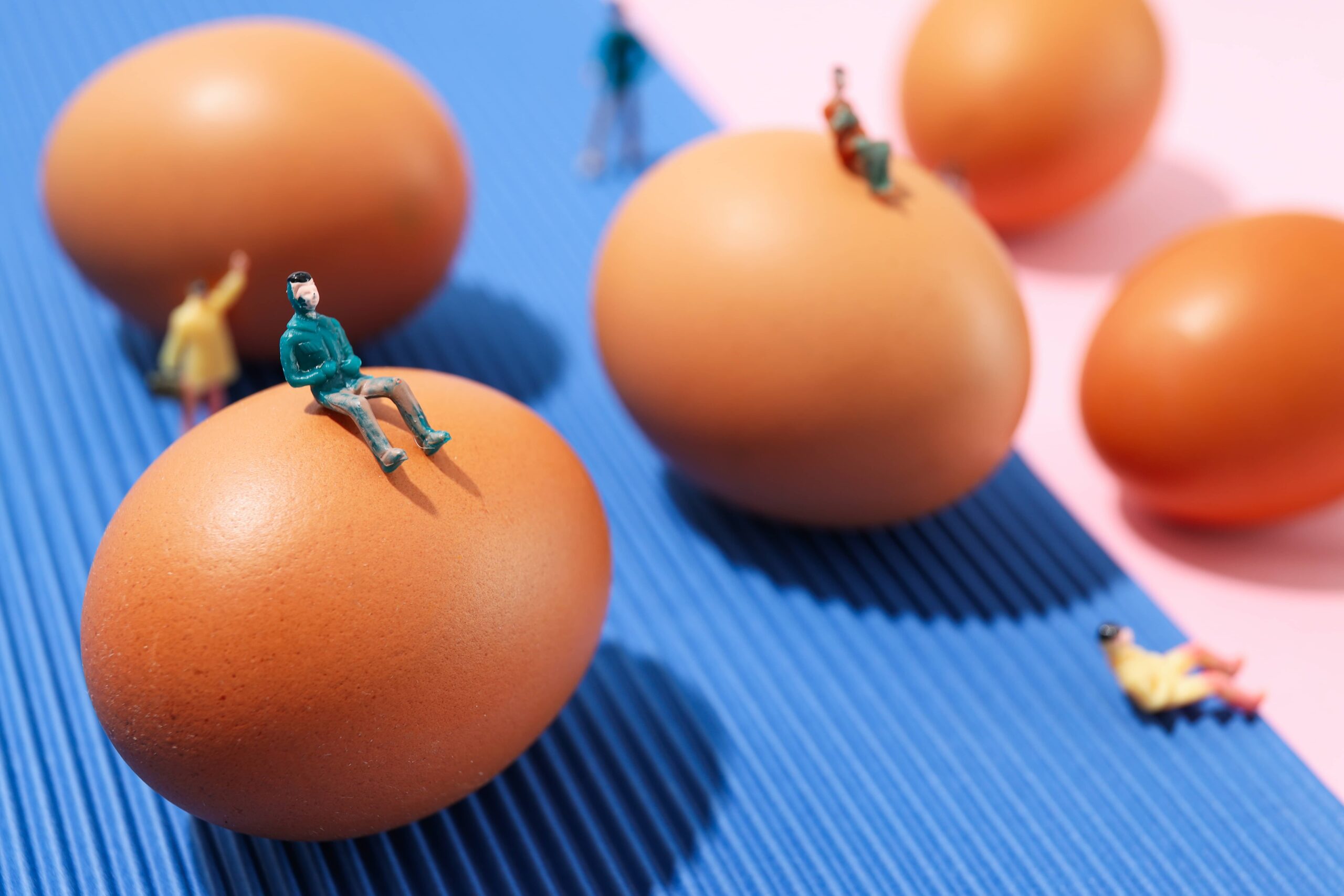 miniature people and eggs on two tone background 2023 11 27 04 54 16 utc scaled